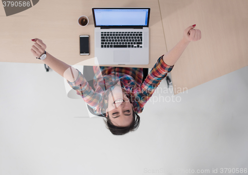 Image of top view of young business woman working on laptop
