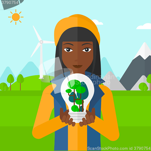 Image of Woman with lightbulb and trees inside.