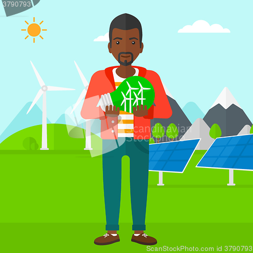 Image of Man holding lightbulb with windmills inside.