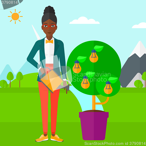 Image of Woman watering tree with light bulbs.