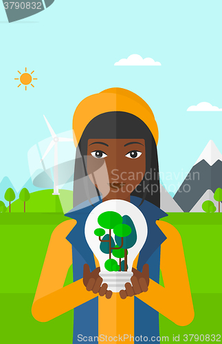 Image of Woman with lightbulb and trees inside.