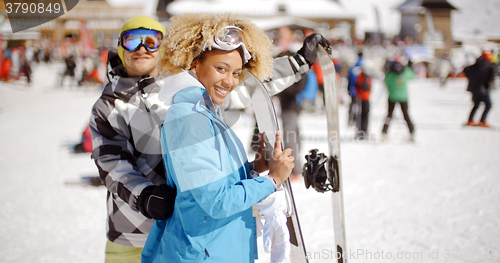 Image of Man flirting with woman holding snowboard