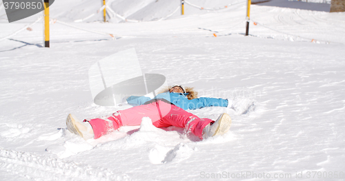 Image of Young woman making a angel in white snow