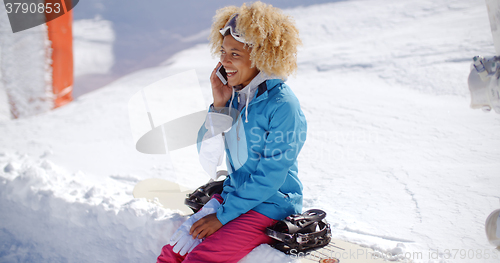 Image of Laughing woman chatting on her mobile in snow