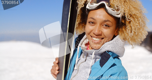 Image of Thoughtful young woman standing holding her skis