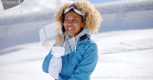 Image of Happy adult in snowsuit with cell phone