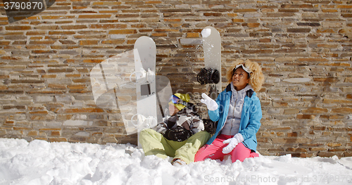 Image of Snowboarding friends sitting in pile of snow