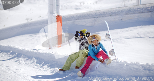 Image of Young couple getting ready to go snowboarding