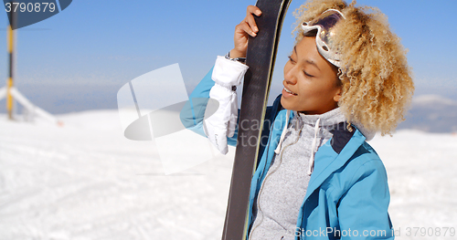 Image of Beautiful woman holding skis with copy space