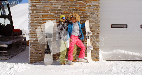 Image of Cute couple leaning against ski resort garage