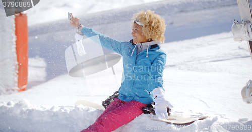 Image of Happy young woman posing for a winter selfie