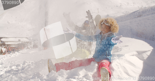 Image of Young couple playing in the snow at a ski resort