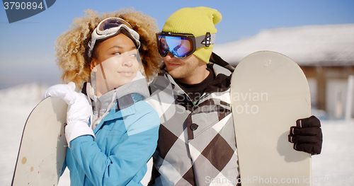 Image of Affectionate young couple posing with snowboards