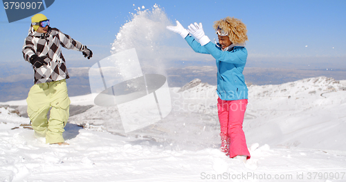 Image of Couple in snowsuits playing the snow