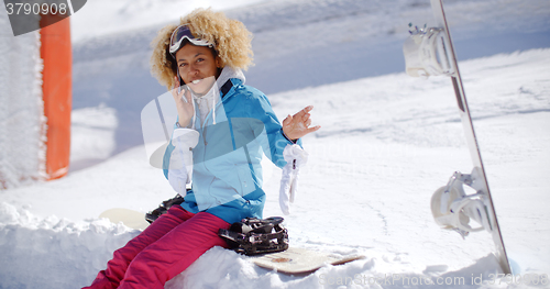 Image of Laughing woman chatting on her mobile in snow