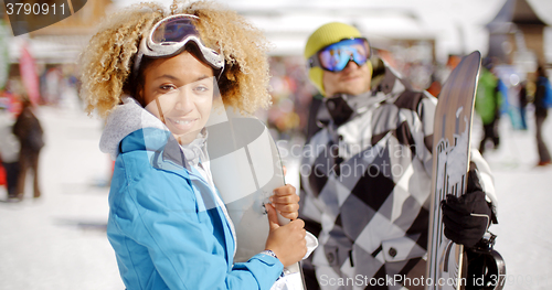 Image of Cute woman holding snowboard on ski slope