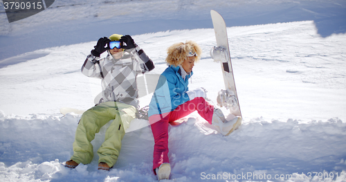 Image of Young couple getting ready to go snowboarding