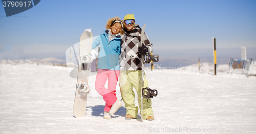 Image of Happy young couple posing with their snowboards