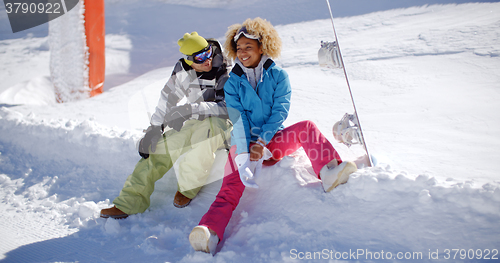 Image of Happy young couple relaxing on a snow shelf