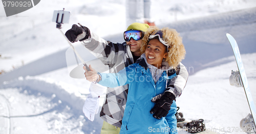 Image of Fun young couple posing in the snow for a selfie