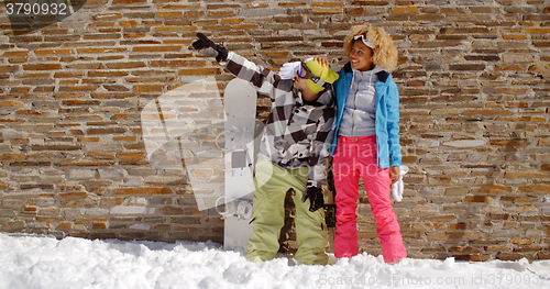 Image of Snowboarder with happy friend pointing upwards