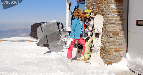 Image of Couple kissing behind ski resort garage