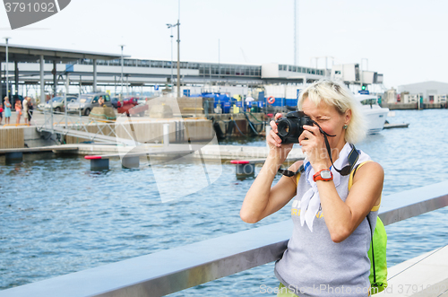 Image of Woman photographs on the quay