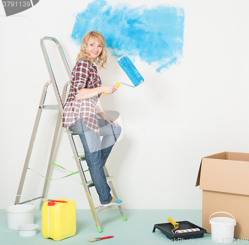 Image of Happy woman makes repairs at home