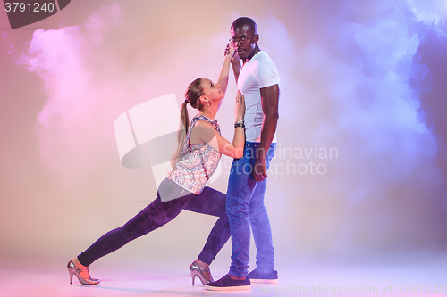 Image of Young couple dances social Caribbean Salsa, studio shot 