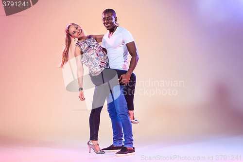 Image of Young couple dances social Caribbean Salsa, studio shot 