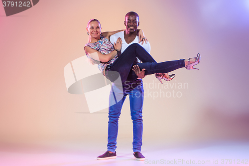 Image of Young couple dances social Caribbean Salsa, studio shot 
