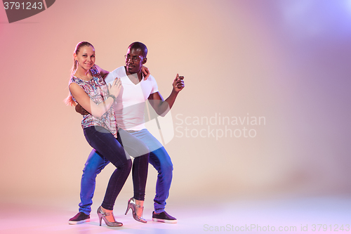 Image of Young couple dances social Caribbean Salsa, studio shot 