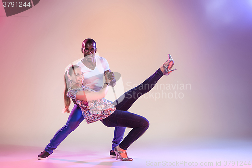 Image of Young couple dances social Caribbean Salsa, studio shot 