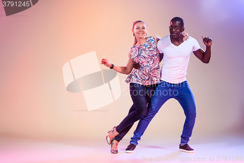 Image of Young couple dances social Caribbean Salsa, studio shot 