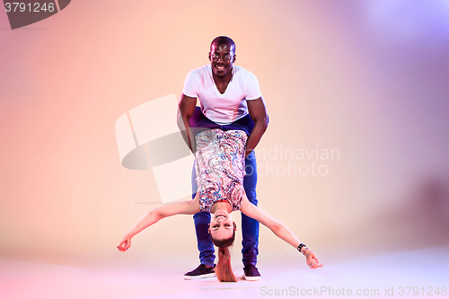 Image of Young couple dances social Caribbean Salsa, studio shot 