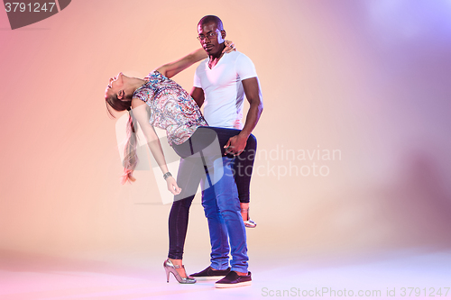 Image of Young couple dances social Caribbean Salsa, studio shot 