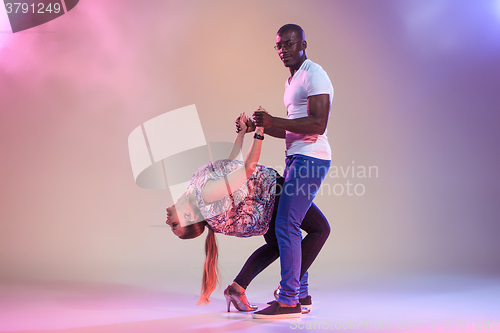 Image of Young couple dances social Caribbean Salsa, studio shot 