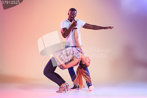 Image of Young couple dances social Caribbean Salsa, studio shot 