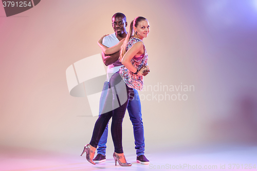 Image of Young couple dances social Caribbean Salsa, studio shot 