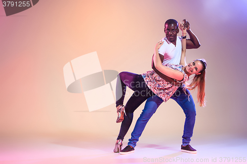 Image of Young couple dances social Caribbean Salsa, studio shot 