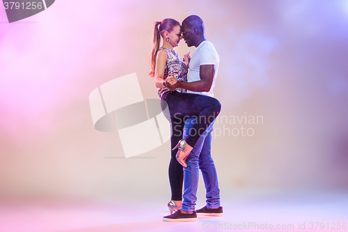 Image of Young couple dances social Caribbean Salsa, studio shot 