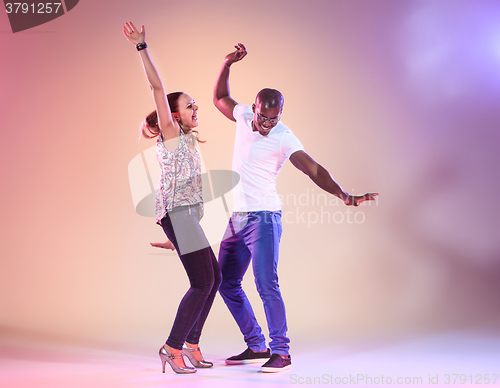 Image of Young couple dances social Caribbean Salsa, studio shot 