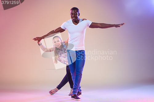 Image of Young couple dances social Caribbean Salsa, studio shot 