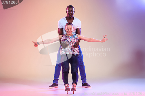 Image of Young couple dances social Caribbean Salsa, studio shot 