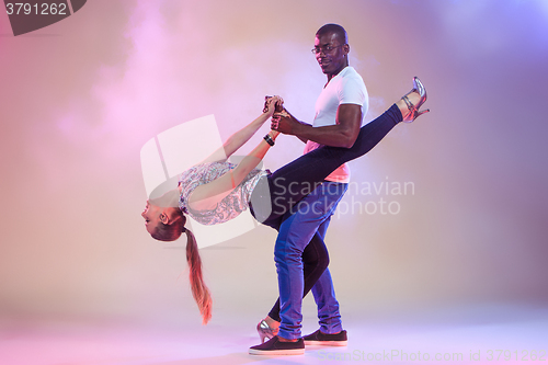 Image of Young couple dances social Caribbean Salsa, studio shot 