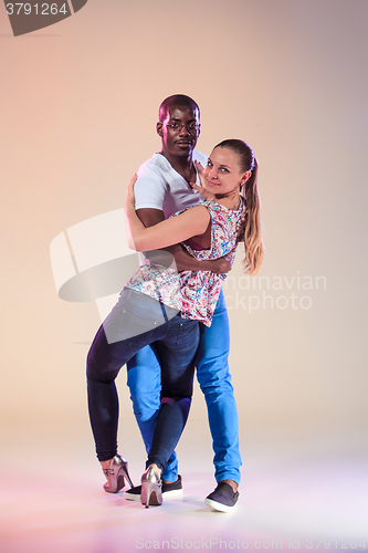 Image of Young couple dances social Caribbean Salsa, studio shot 