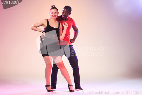Image of The young cool black man and white woman is dancing