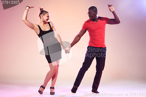 Image of The young cool black man and white woman is dancing