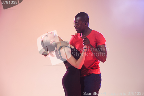 Image of Young couple dances social Caribbean Salsa, studio shot 