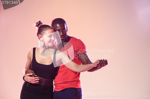 Image of Young couple dances social Caribbean Salsa, studio shot 